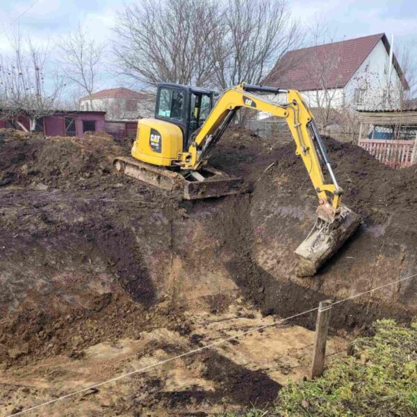 Міні-екскаватор CAT 303.SE копає котлован під фундамент