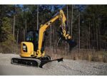 Міні-екскаватор CAT 303.SE виконує земляні роботи на ділянці