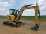 Міні-екскаватор CAT 305.5E виконує земляні роботи на відкритій ділянці